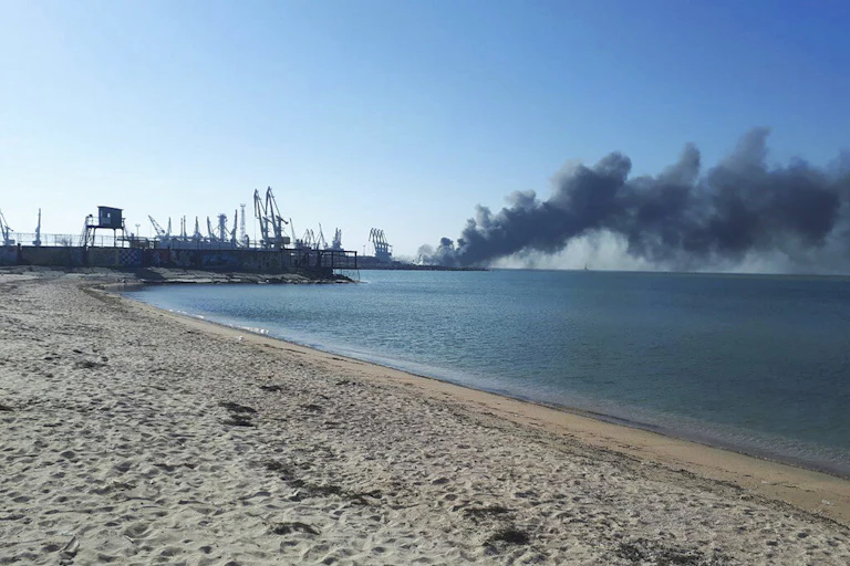 Smoke billows from a ship in the sea.