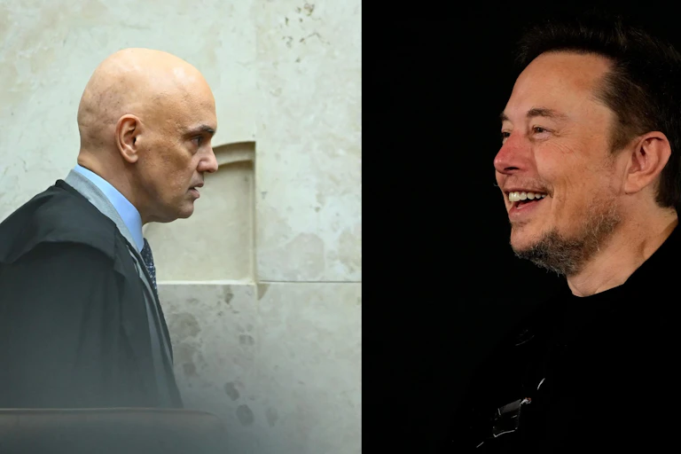 A bald man in a cloak and a smiling man.