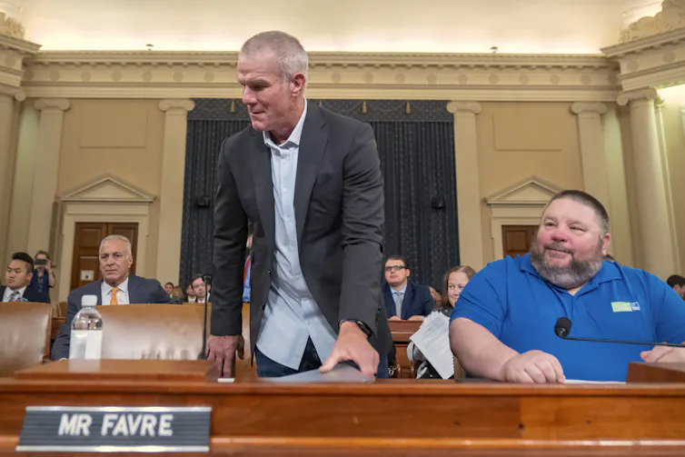 A man standing behind a table where others are seated