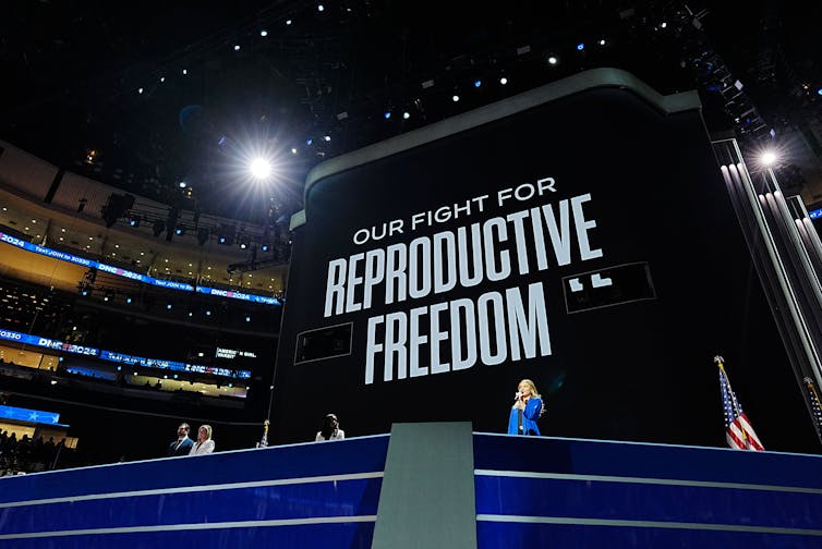 A large black sign with white writing says 'Our fight for reproductive freedom.'
