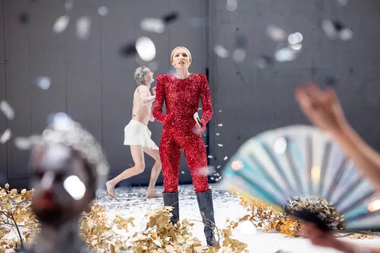 A woman in red stands on stage.