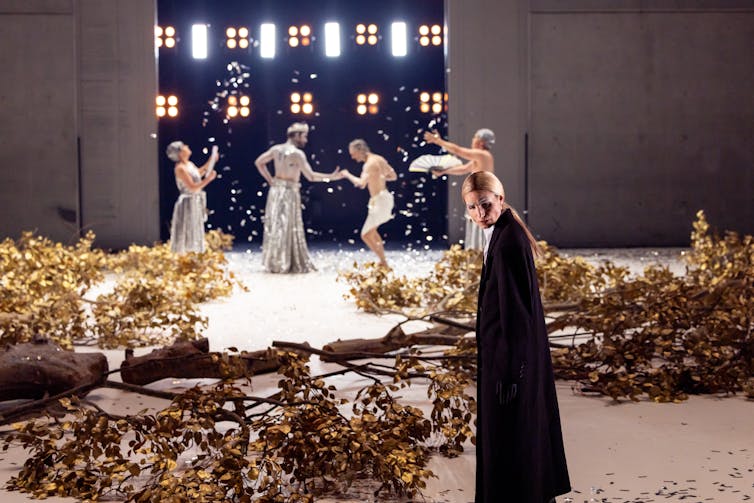 Golden trees lie across the stage.