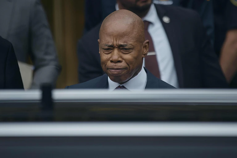 A man with shaved head and a sad expression.