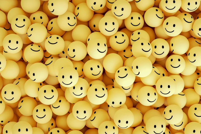 A bunch of yellow-faced smiling emojis all piled together.