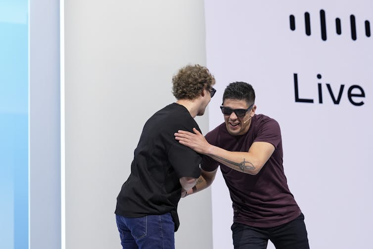 Two men shaking hands on stage.