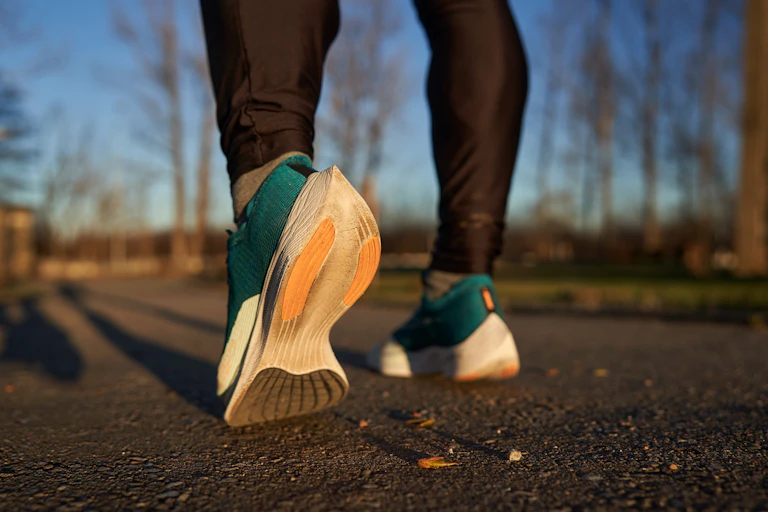 Close-up of a person wearing Nike Vaporfly running shoes.