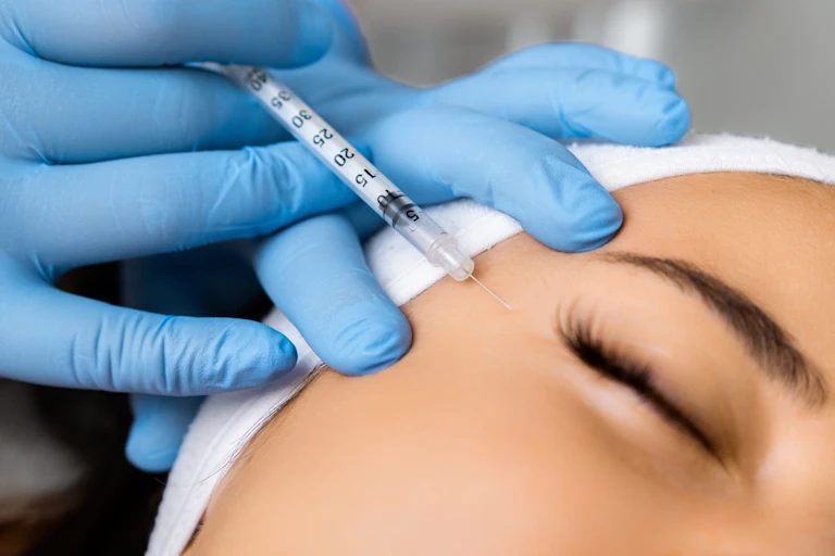A woman has a Botox needle injected near her eye.