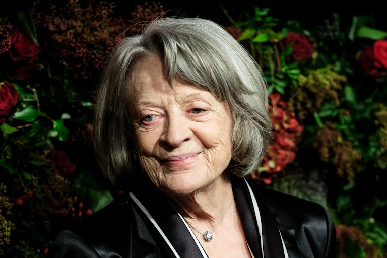Maggie Smith in front of a flower wall.