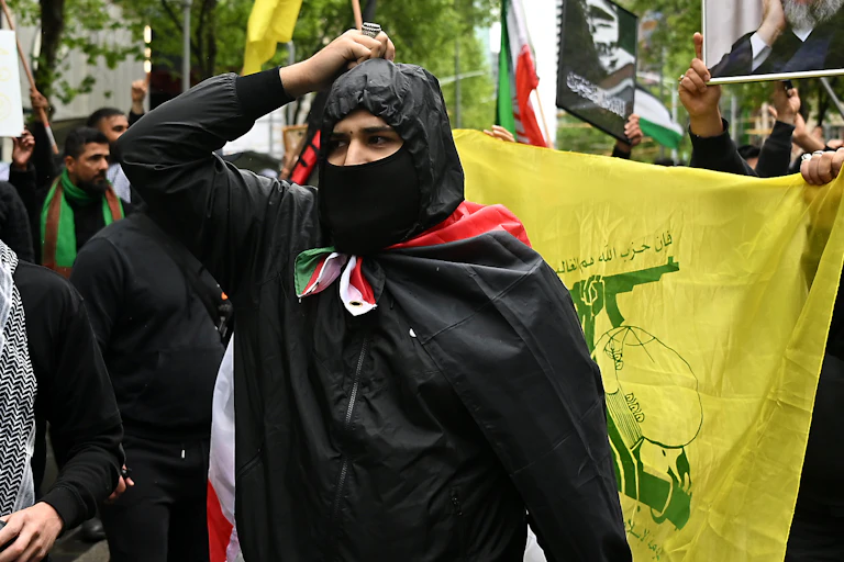 Protesters march holding a photo of Hezbollah Secretary-general Hassan Nasrallah and a Hezbollah flag during a Pro-Palestine rally for Gaza and Lebanon at the State Library of Victoria in Melbourne, Sunday, September 29, 2024