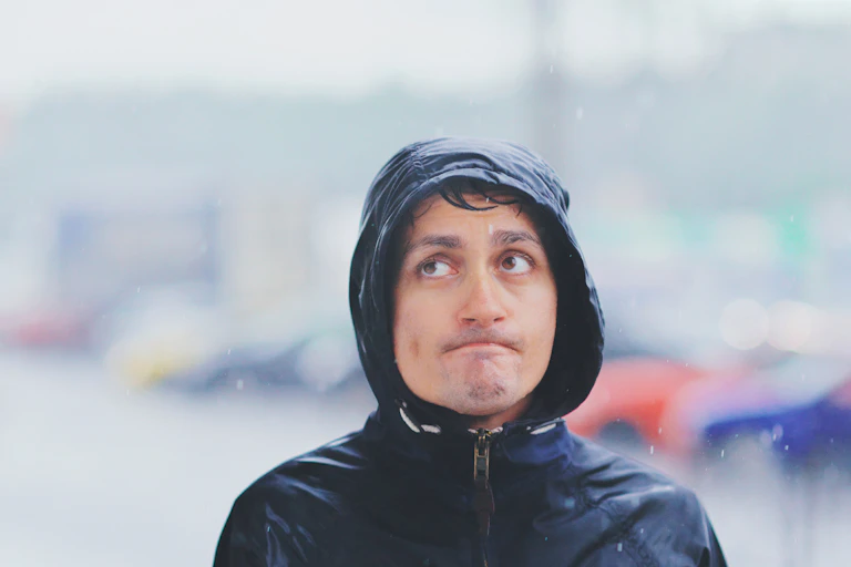 Un hombre con un chubasquero bajo la lluvia.