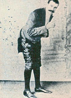 historical photo of man wearing suit and bending forward