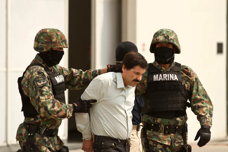 El Chapo being led away by Mexican soldiers.