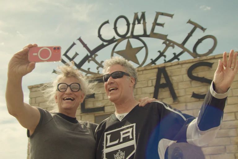 Harper Steele and Will Ferrell taking a selfie in front of a Texas sign.