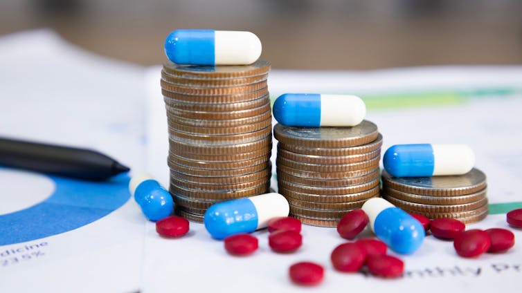Stacks of coins with pills and capsules