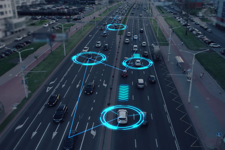 Futuristic concept of cars driving down a road with a digital overlay showing data collection.