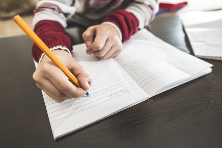 A child writes in a notebook.