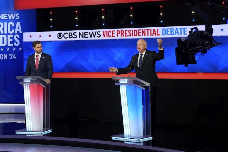 Two men in suits stand behind lecterns