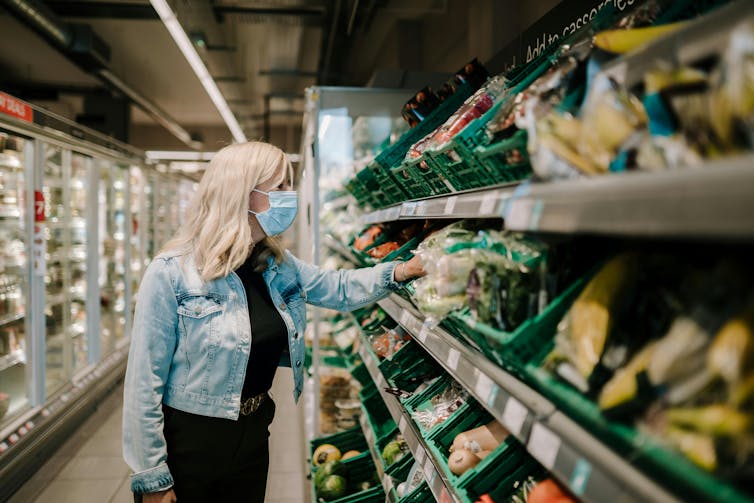 A woman wearing a mask in a supermarket.