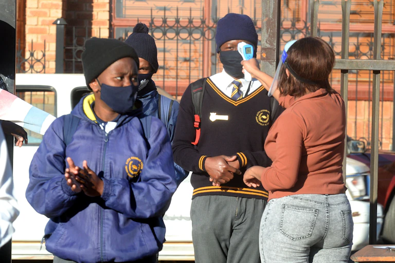 A group of students having their temperature checked