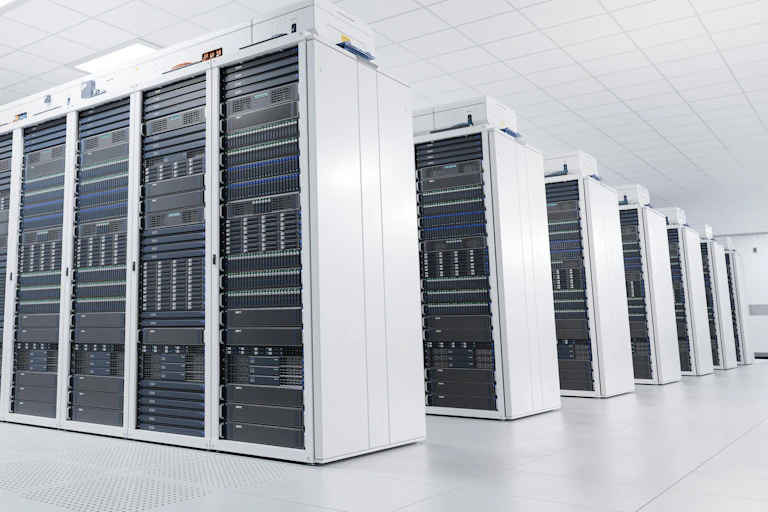 white well-lit warehouse room with rows of supercomputers