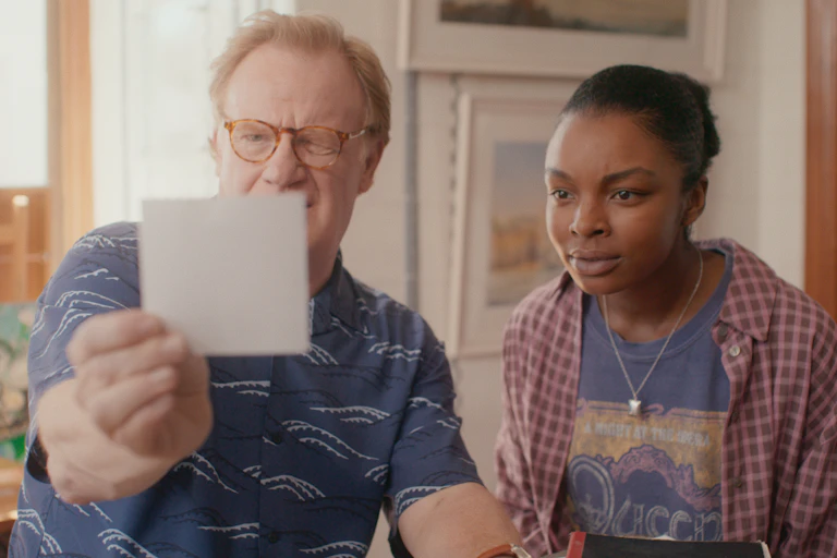 Mark Lewis Jones and Yasmin Monet Prince looking at a photo