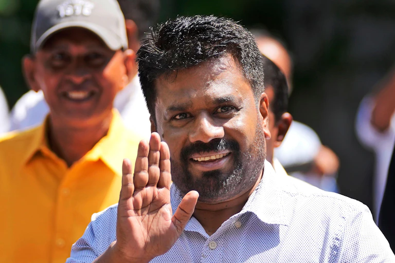 Anura Kumara Dissanayake smiling as he waves his hand.