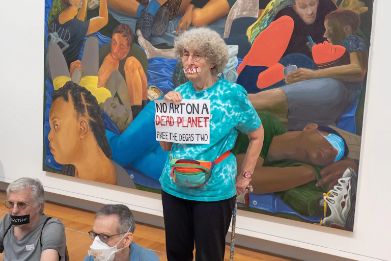 Woman holds 'no art on a dead planet' sign