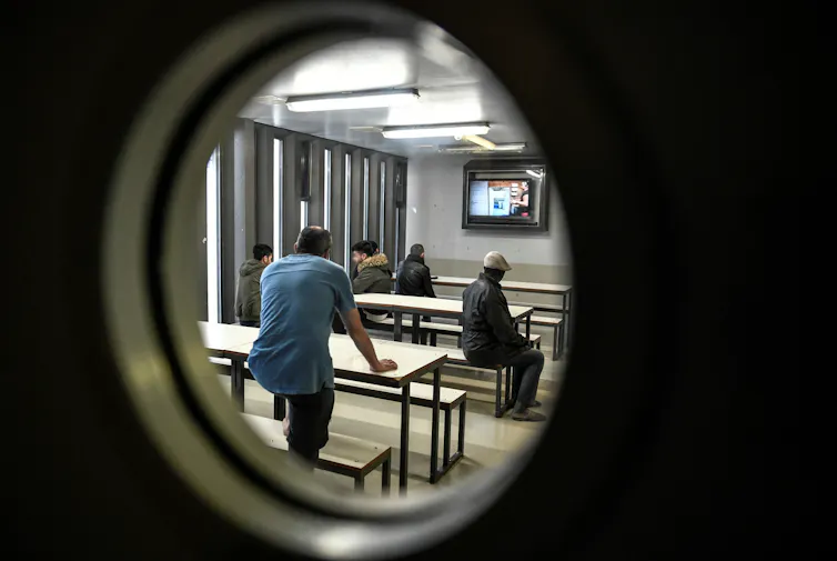 Des hommes regardent la télévision dans une salle du Centre de rétention administrative (CRA) à Vincennes (Val de Marne), le 18 septembre 2019
