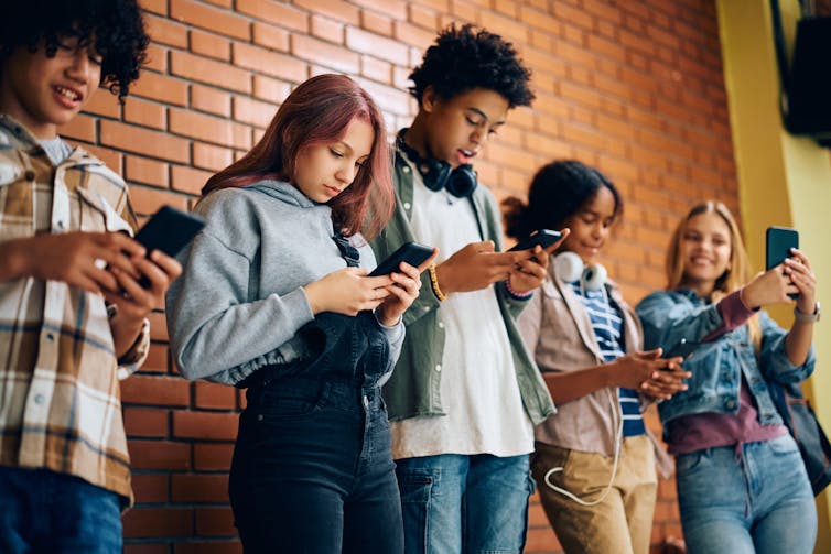 Teenagers looking at their phones