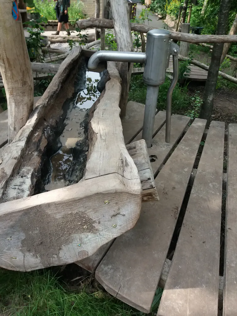 Una fuente rústica construida con troncos de madera.