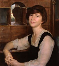 Portrait of a woman sat at a writing desk.