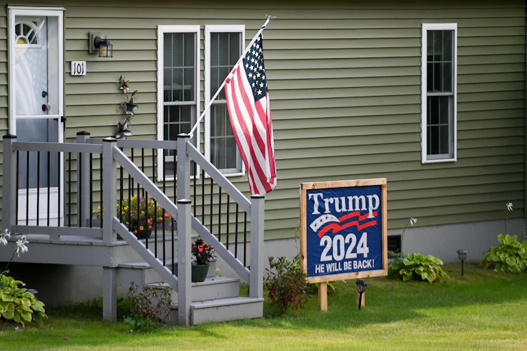 A US flag and Trump sign outside a house.