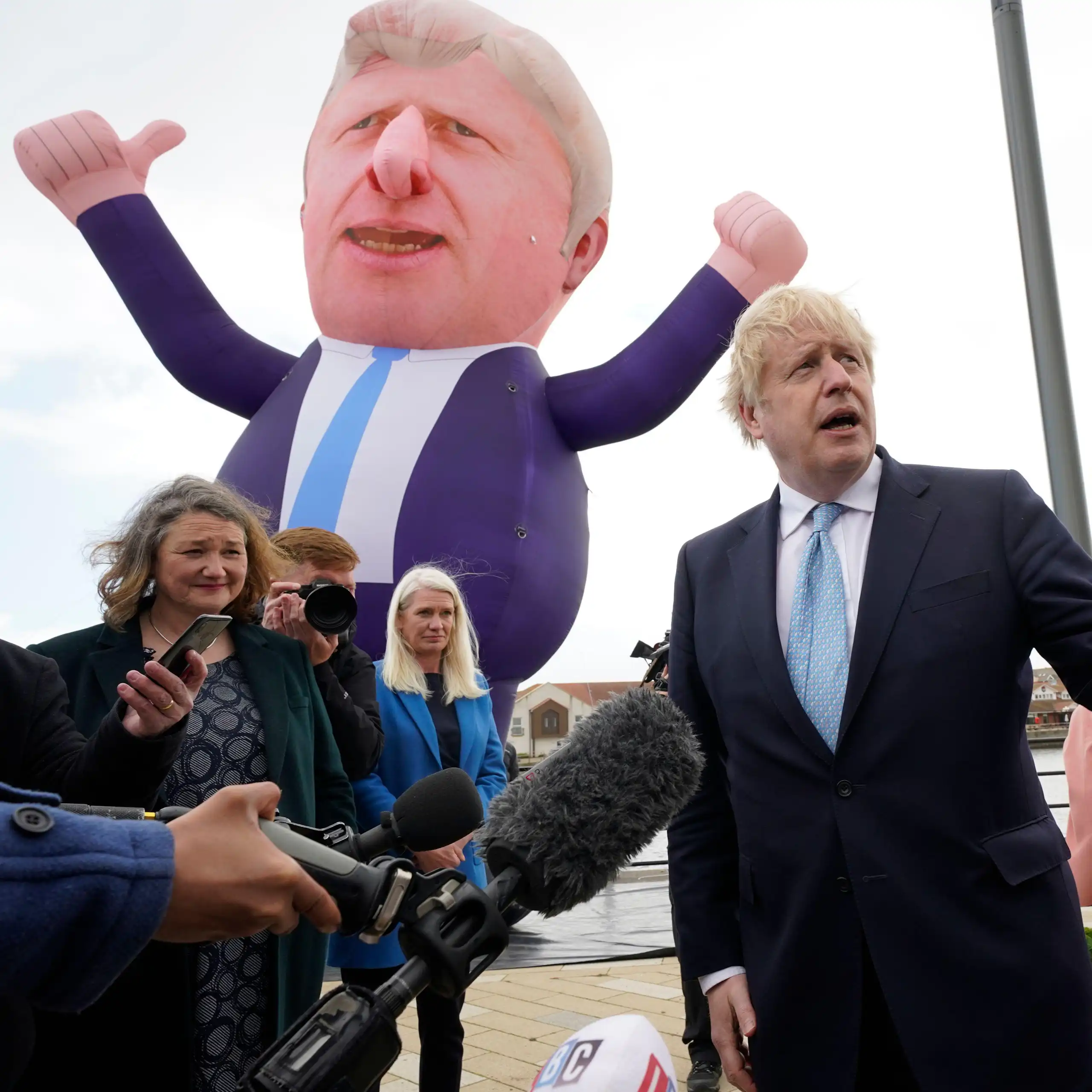 Boris Johnson stands in front of a blow-up version of himself.