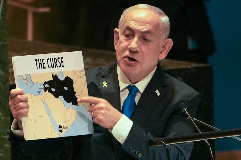 Israeli Prime Minister Benjamin Netanyahu holds up a map titled "The Curse" with hostile regions marked in black