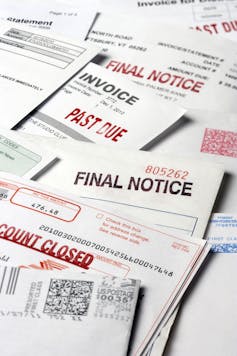 A stack of statements and invoices indicating a past due status on the accounts