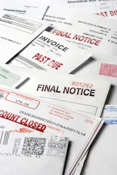 A stack of statements and invoices indicating a past due status on the accounts
