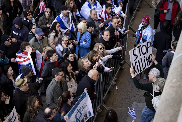Two groups of protestors shouting at each other.