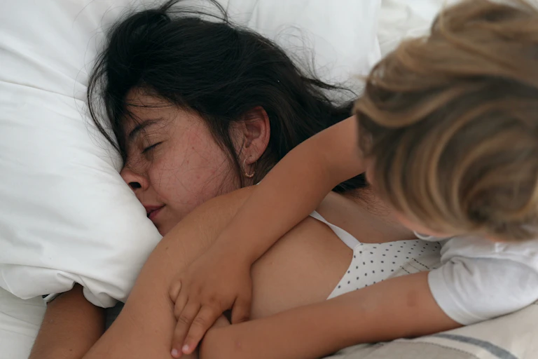 A boy tries to wake up his sleeping mum.