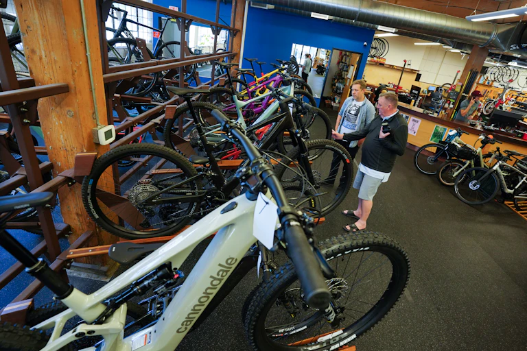 A bike shop assistant serves a customer interested in buying an e-bike