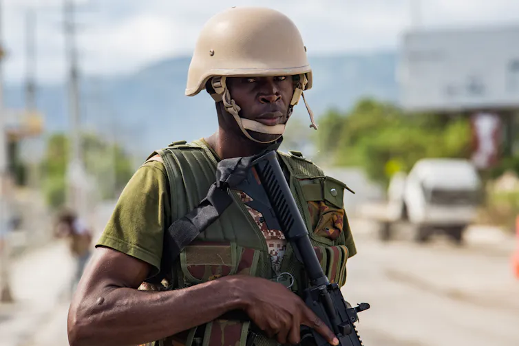 A kenyan police officer holding a gun.
