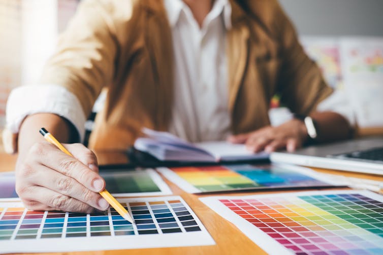 a person sitting at a table with various colour swatched in front of them