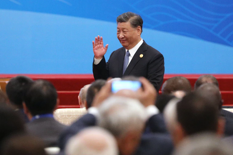 Xi Jinping greeting a hall of people.