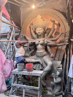 A man sculpting an idol of a goddess