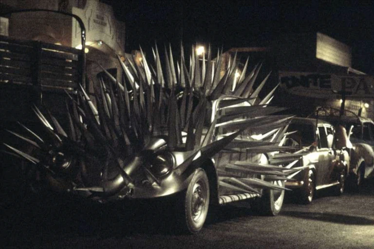 car parked on street that is covered in sharp spikes