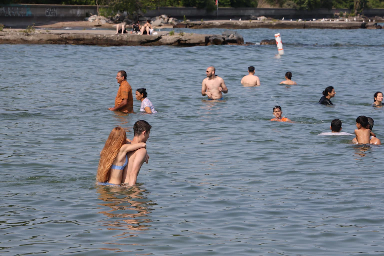 About a dozen people swim and relax in a body of water