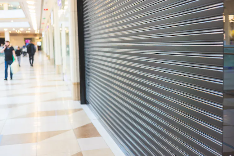 A storefront is closed with a metal shutter.