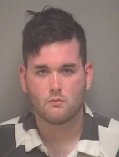 An image of a white man staring into a camera at a police station.