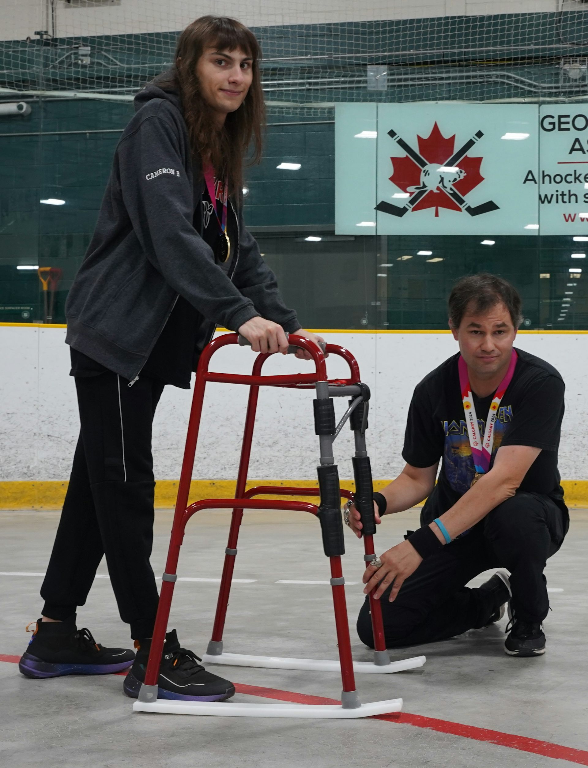 Two people standing with an assistive device on ice.
