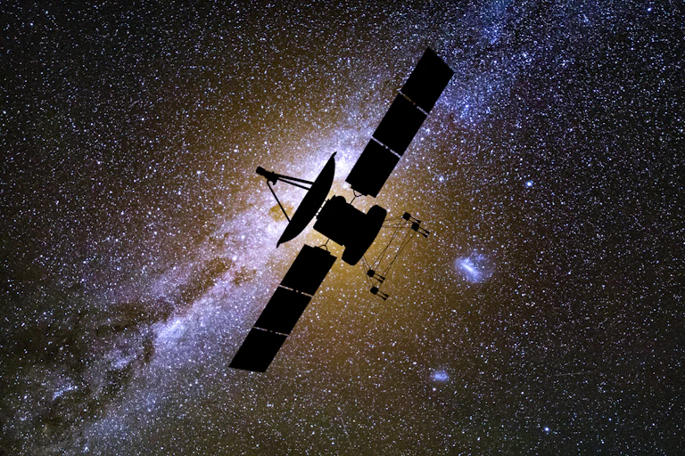 An outline of a satellite against the sky and lots of stars.