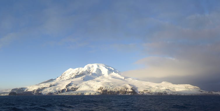 island with snow against blue sky